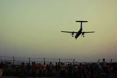 Group of people in airplane against clear sky