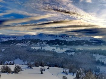 Scenic view of snow covered mountains against sky