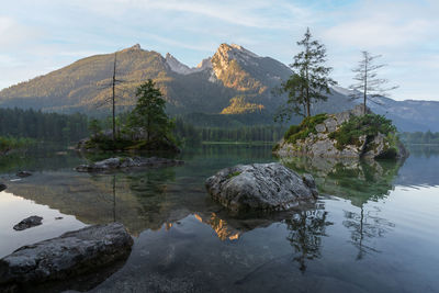Crystal clear alpine tarn with rocky islands scene during sunrise, hintersee, germany