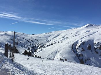 People on snowcapped mountain against sky