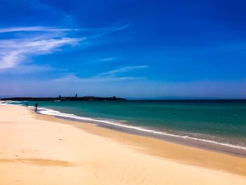 Scenic view of beach against blue sky