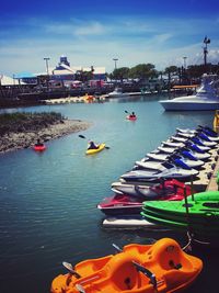 Boats moored at harbor against sky