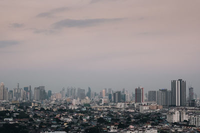 Aerial view of buildings in city against sky