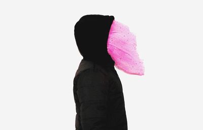 Close-up of woman holding pink umbrella against white background