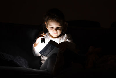 Portrait of young woman sitting on sofa at home