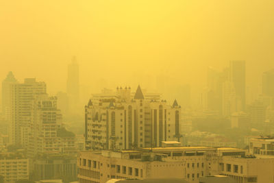 Smog city in summer with morning sunlight, haze of pollution covers city, global warming concept