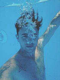 Underwater portrait of shirtless man in swimming pool