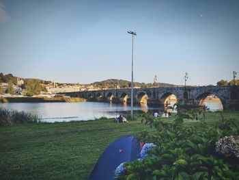 Arch bridge over river against sky