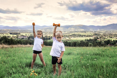 Full length of girl on field against sky