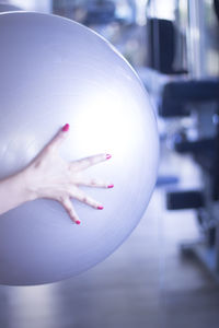 Cropped hand of woman holding fitness ball