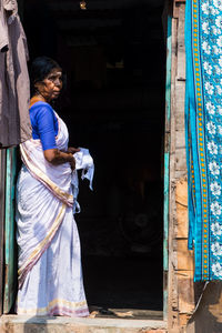 Rear view of woman standing against door