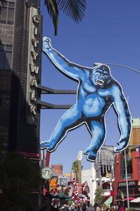 Low angle view of statue against building against blue sky