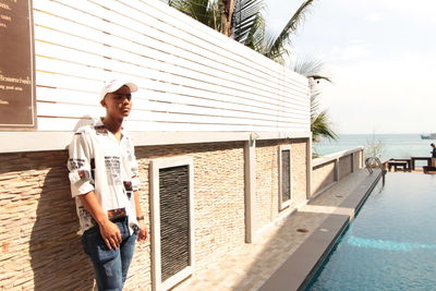 Young man standing by swimming pool