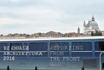 Information sign in city against sky