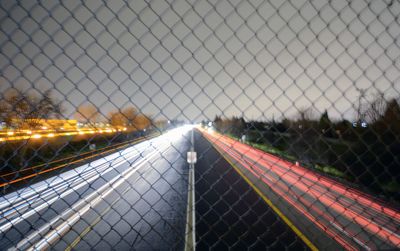 Close-up of illuminated chainlink fence against sky