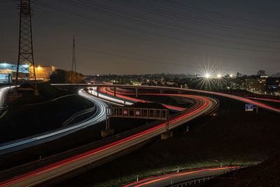 Light trails on road against sky at night