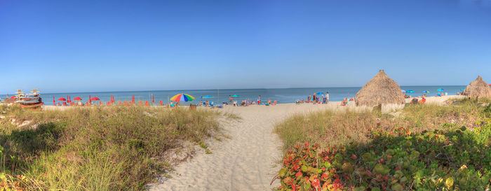 Scenic view of beach against clear blue sky