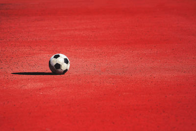 Soccer ball on red land during sunny day