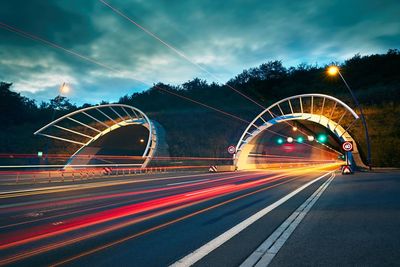 Light trails on road against sky at night