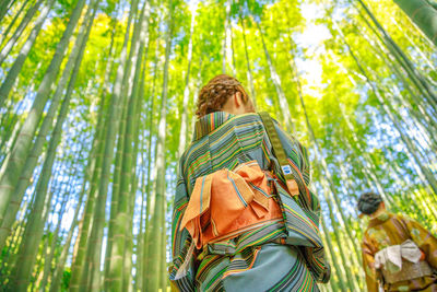 Low angle view of man standing in forest