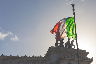 Low angle view of flag on building against sky