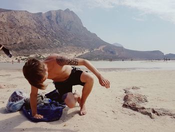 Shirtless boy on sea shore