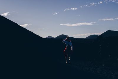 Woman standing on mountain against sky