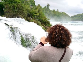 Rear view of woman looking at waterfall