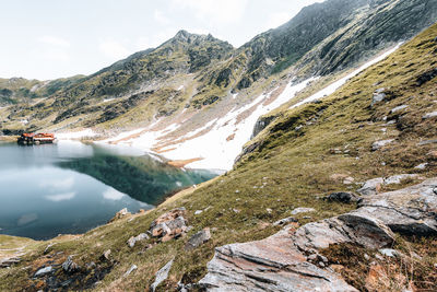 Lake on transfagarasan with snowy ridges and reflection