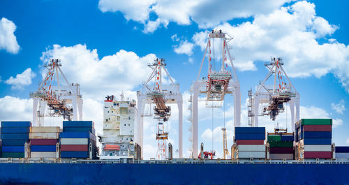 Cranes on pier against sky