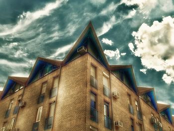 Low angle view of building against cloudy sky