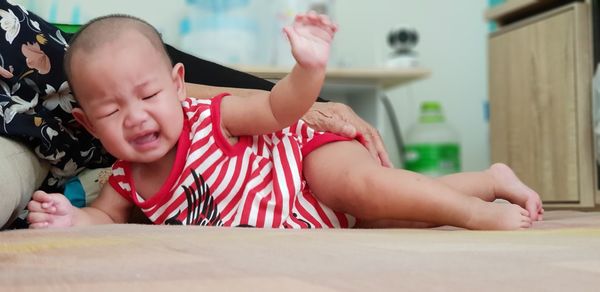 Cute baby girl lying on bed at home