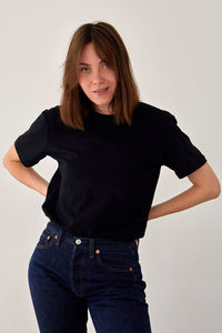 Smiling woman in casual outfit standing in studio