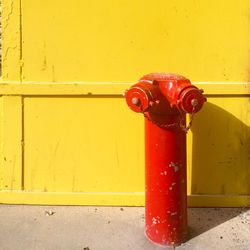 Close-up of fire hydrant against yellow wall