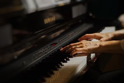 Close-up of hand playing piano