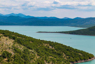 Scenic view of lake and mountains against sky