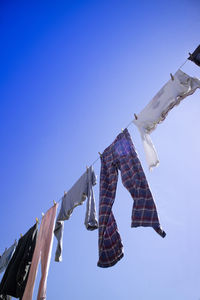 Low angle view of flags against clear blue sky