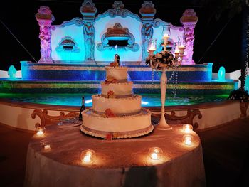 Close-up of illuminated candles on table at night