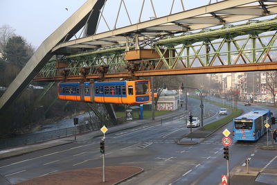 Vehicles on road against bridge in city