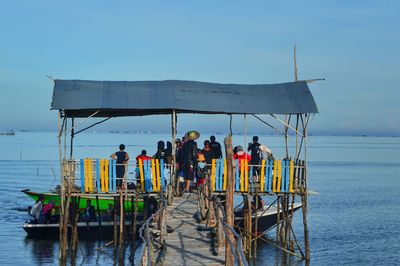 People standing on boat in sea against sky