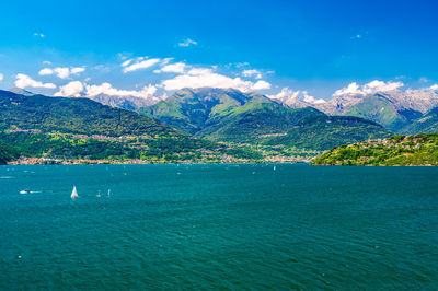 Scenic view of sea and mountains against blue sky