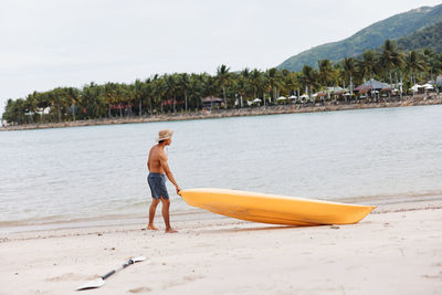 Rear view of woman standing at beach