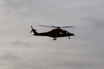 Low angle view of helicopter flying against sky