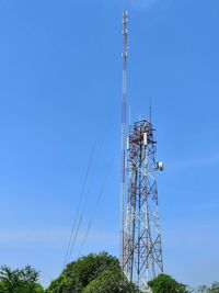 Low angle view of communications tower against blue sky