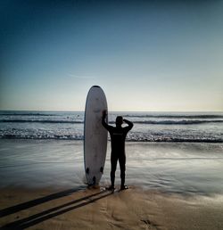 Man standing on beach against clear sky