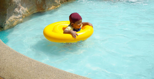 Smiling boy in swimming pool at tourist resort