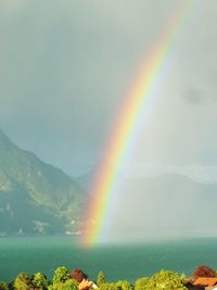 Scenic view of rainbow over mountains against sky