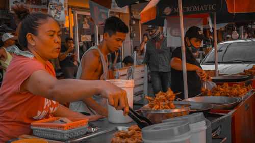 People at market stall in city