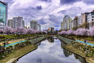 Canal amidst buildings against sky