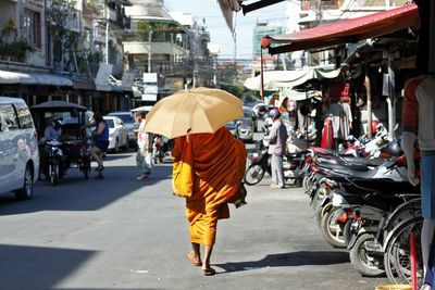 Rear view of monk walking on road